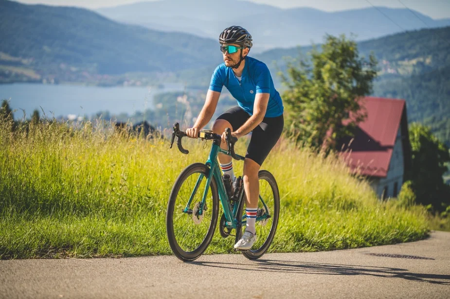 Mateusz Witkowski na stromym podjeździe w odzieży rowerowej Nessi Sportswear